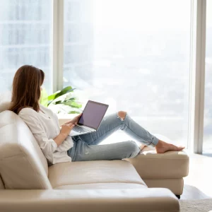 woman relaxing at home on sofa on laptop